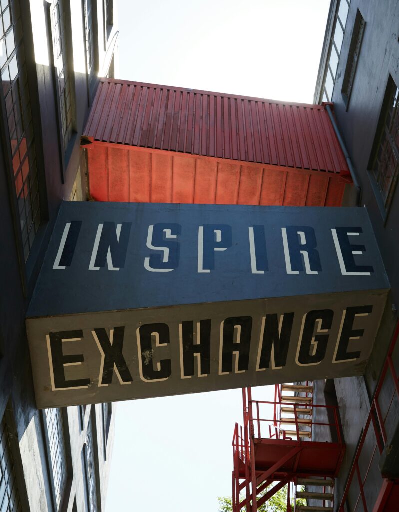 From below of connecting bridges with Inspire and Exchange inscriptions placed between buildings in city in daytime